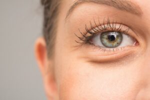 Close-up of a made-up woman's green eye.